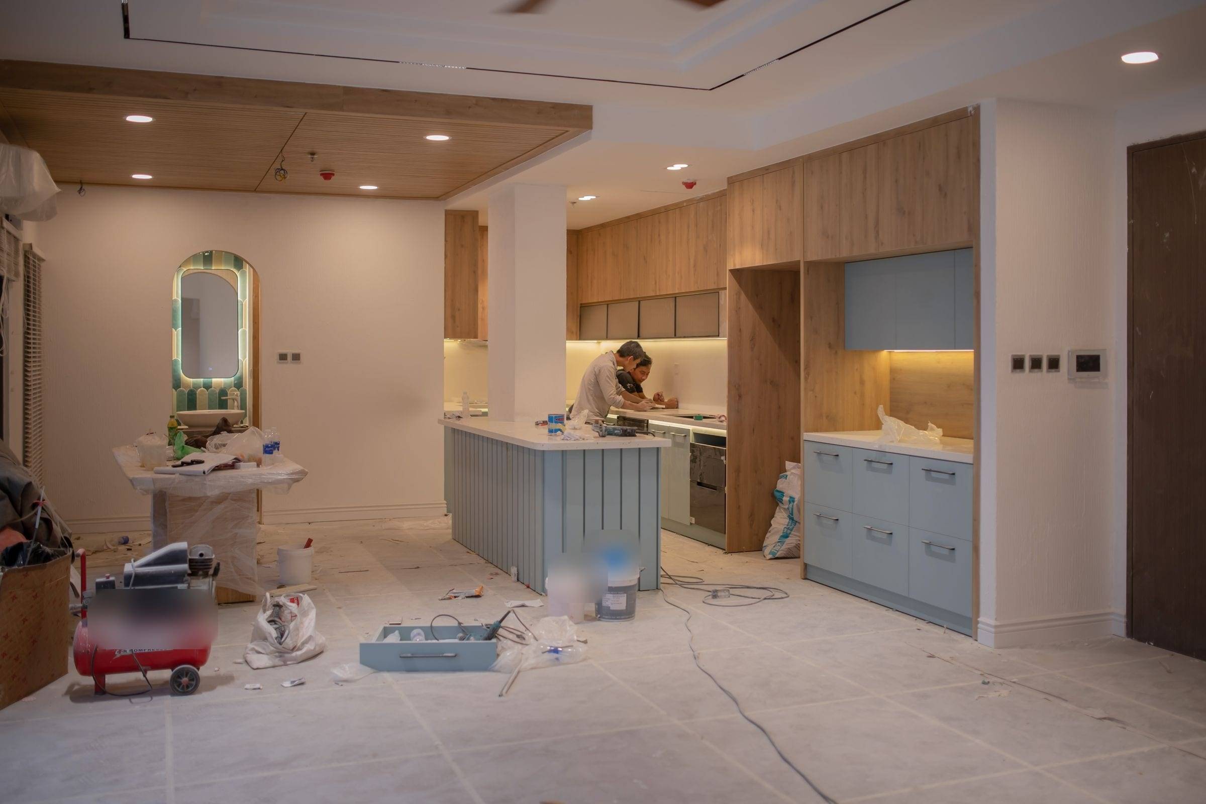 Chantier de pose d’une cuisine ouverte avec îlot, sol protégé et outillage